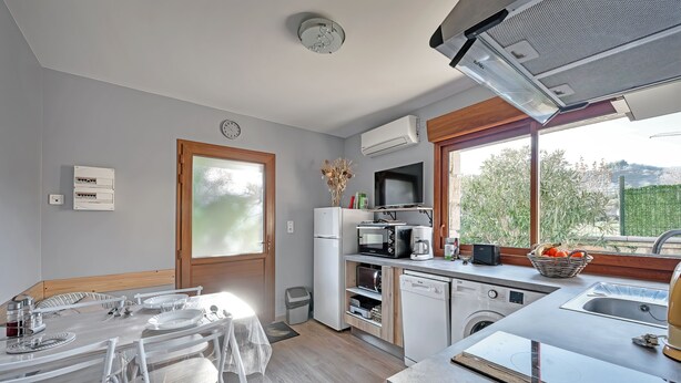 Una cocina moderna con comedor, equipada con microondas, horno y lavavajillas.