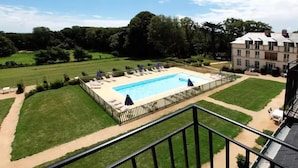 A rectangular swimming pool with a fenced deck, surrounded by well-maintained lawns and trees. - Kergonano - Parking privé et piscine (Baden)