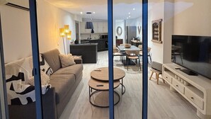 Een moderne woonkamer met een bank, salontafel en tv-meubel.