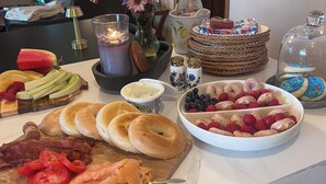 Un bufé de desayuno con diversos alimentos, una vela y un florero.
