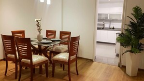 A dining area with a glass table surrounded by wooden chairs, a vase with flowers, and a potted plant. - Beautiful, Bright & Spacious 3-Bedroom Retreat only 3 Blocks to the Ocean (Miraflores)