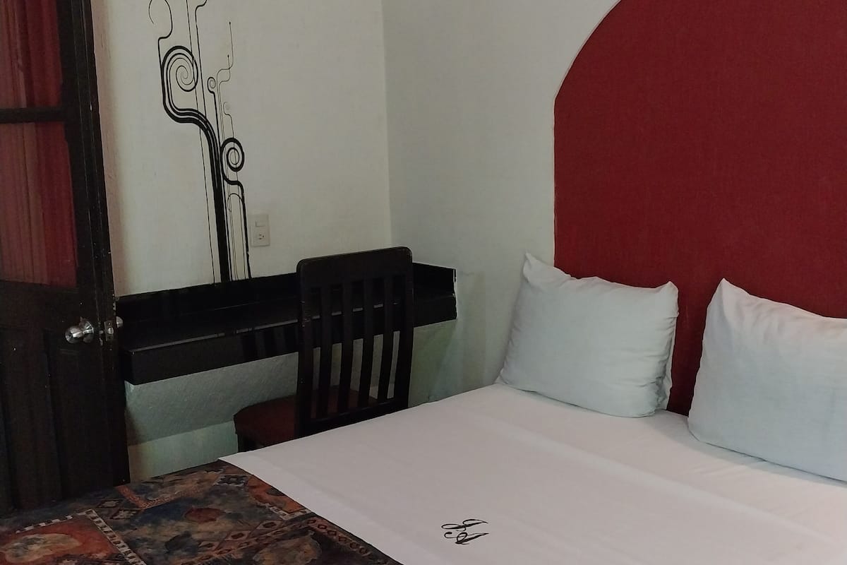 A room with a bed, a desk, and a chair.