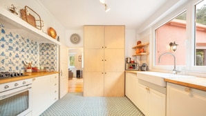 Een keuken met witte kastjes, een betegelde achterwand en een vloer met patroon.