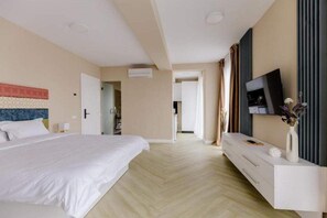 Relax in a serene space with a large bed, flat-screen TV, and elegant console table.