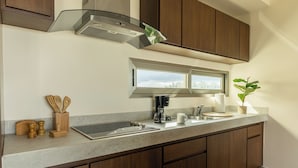 A modern kitchen with a stainless steel range hood, a double sink, and wooden cabinets. - La Poza (Isla Mujeres)