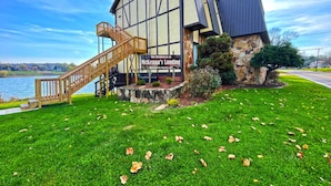 Ein Gebäude mit rustikalem Sockel aus Stein und Obergeschoss aus Holz, eine Holztreppe sowie ein Schild mit der Aufschrift 'The Residences at McKenna's Landing'.