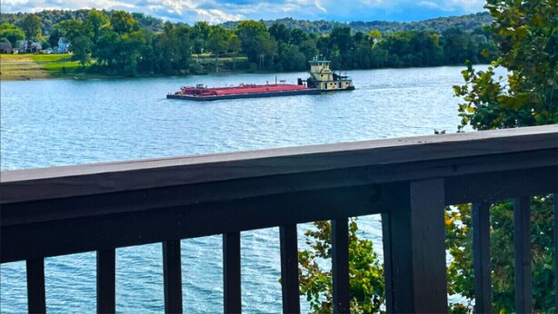 A river with a boat and a dock. - Captain's Quarters | One Bed Condo Waterfront on Ohio River (Marietta)