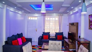 Una sala de estar con un sofá, una mesa de centro y un mueble para televisión.