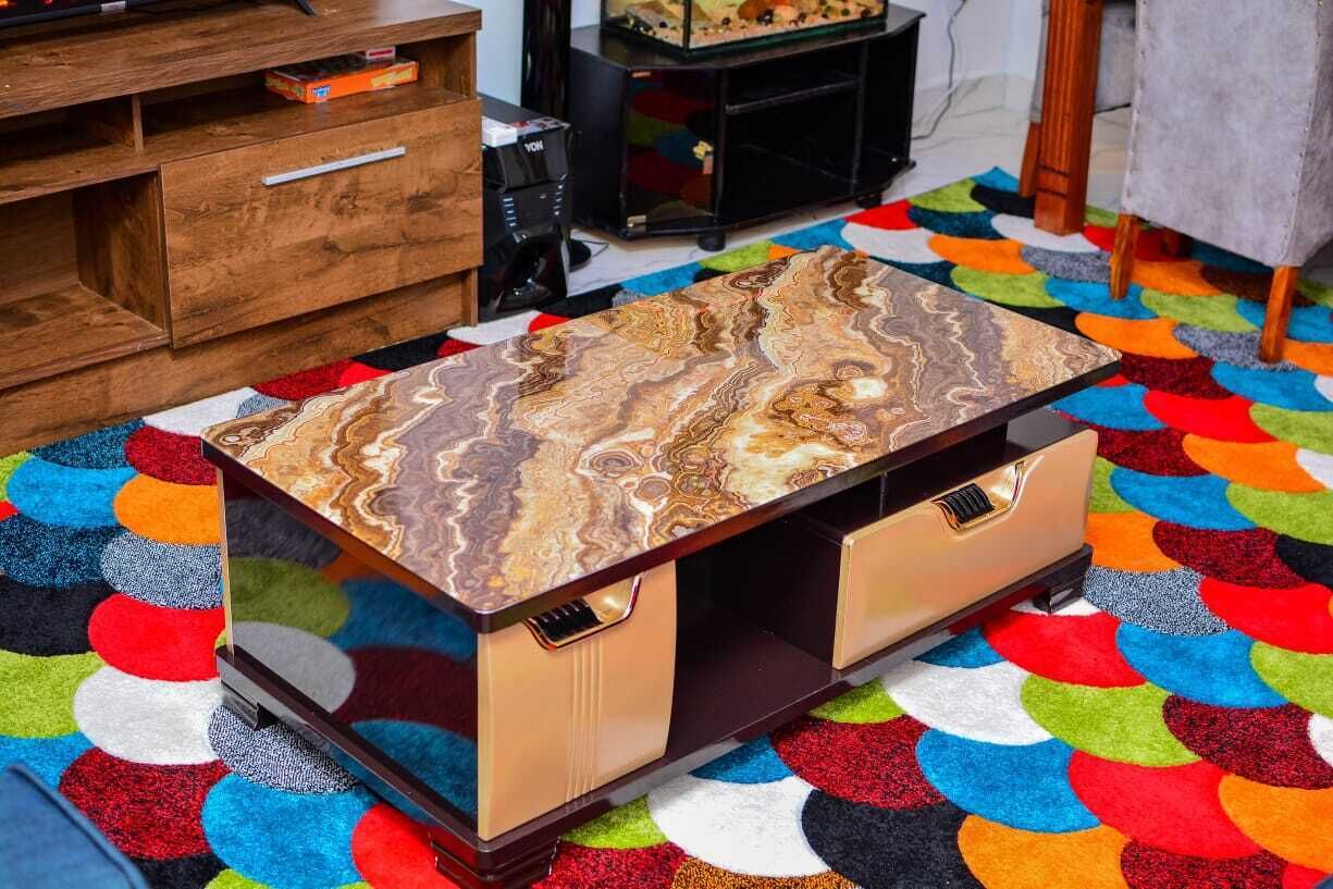 Um armário de madeira com gavetas e uma mesa com tampo de mármore.
