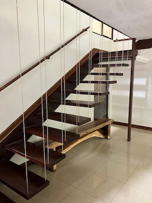 Una escalera moderna con escalones de madera y barandillas de vidrio.