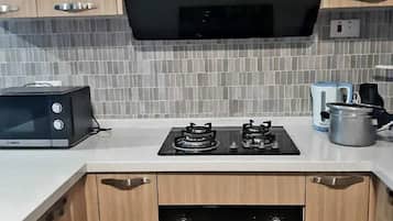 Familie loft | Privékeuken | Een koelkast, een microgolfoven, kookgerei, borden en bestek