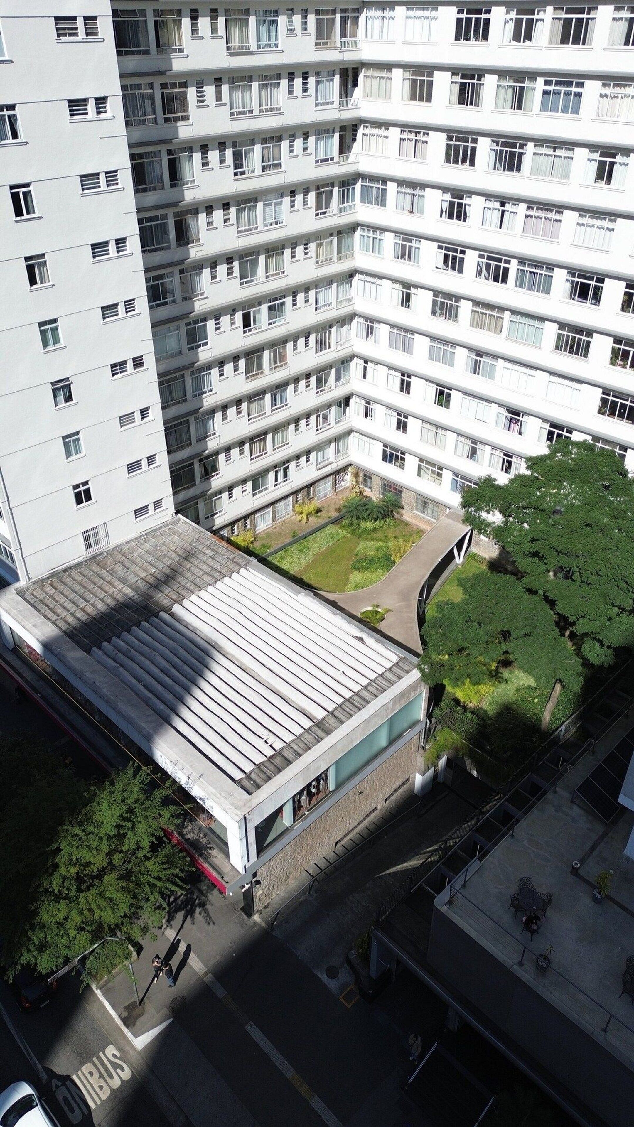 Un edifici d'apartaments de diverses plantes amb terrassa plana i un petit pati interior.