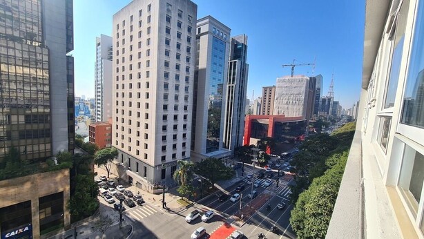 Un paisaje urbano con edificios modernos, un cruce con mucho tráfico y una grúa de construcción al fondo.