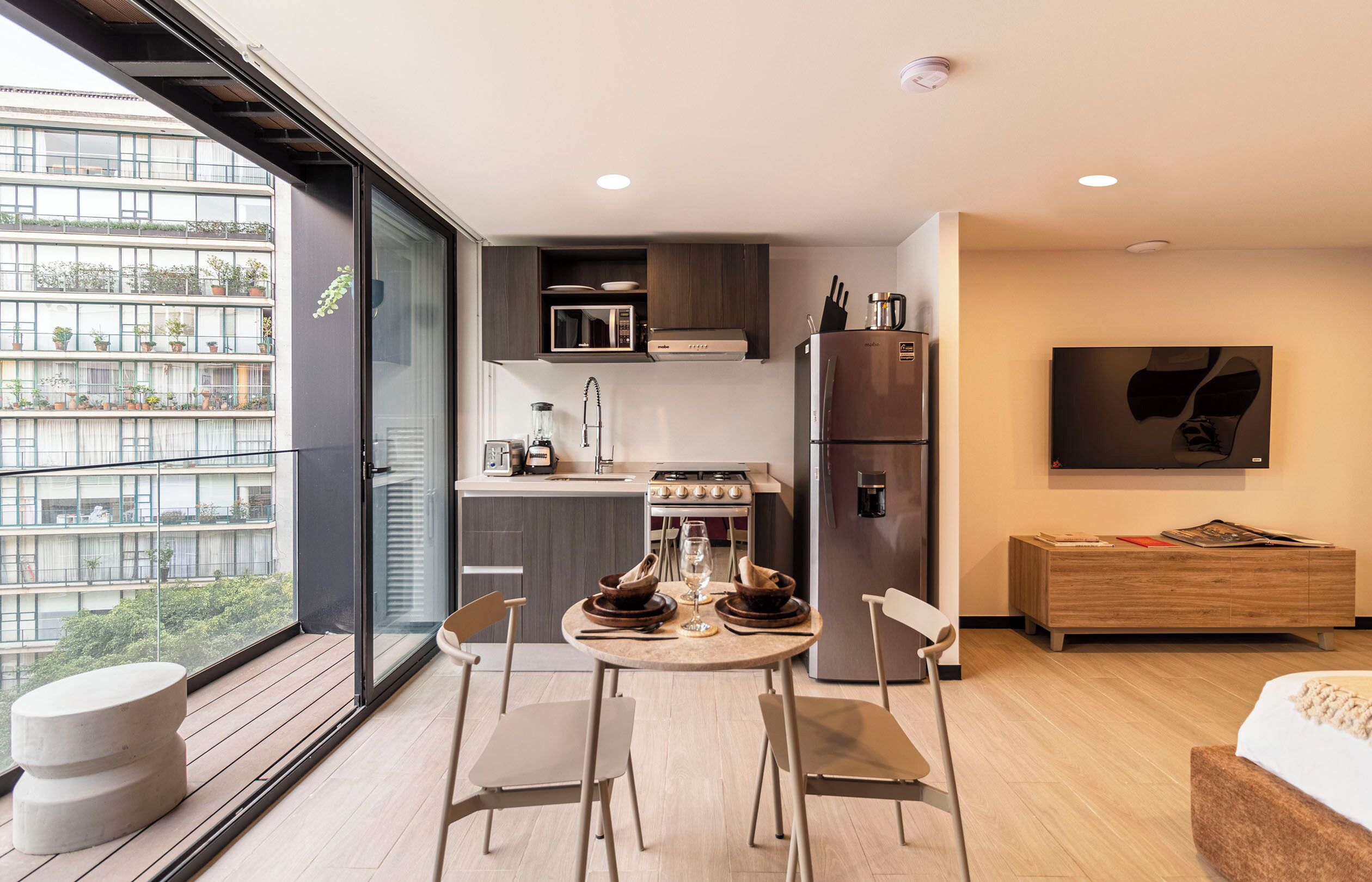 Una cocina moderna con comedor, horno empotrado y refrigerador.