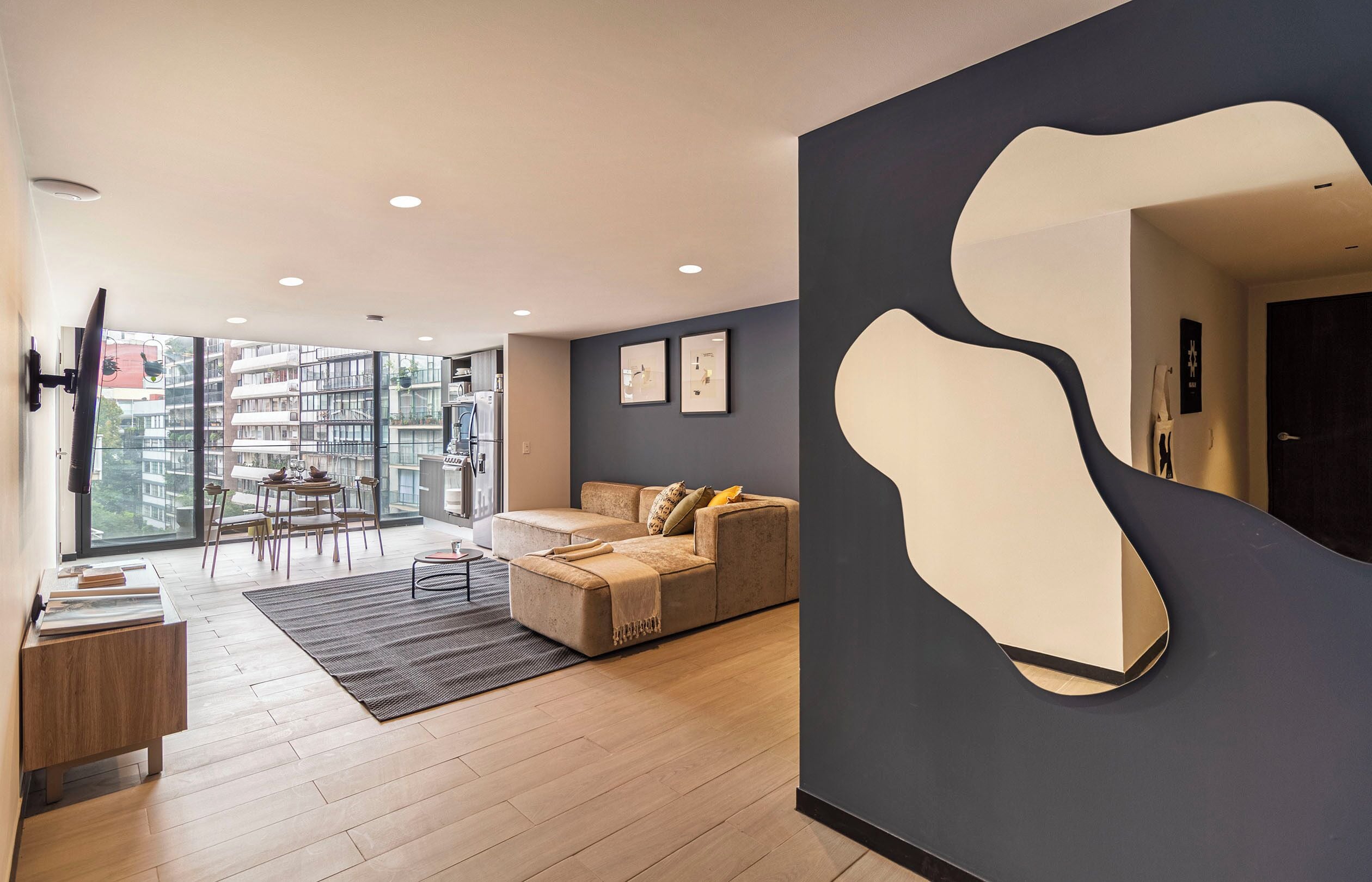 A modern living room with a sofa, a coffee table, and a dining area with chairs.