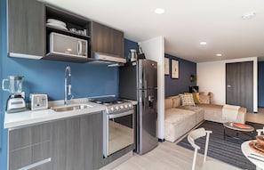 Una cocina moderna con estufa integrada, microondas y refrigerador.