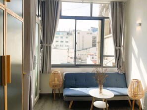 Living area - The Cafe Apartments Building - Deluxe King room has a large window (Hồ Chí Minh)