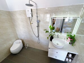 A modern bathroom with a toilet, sink, and shower.