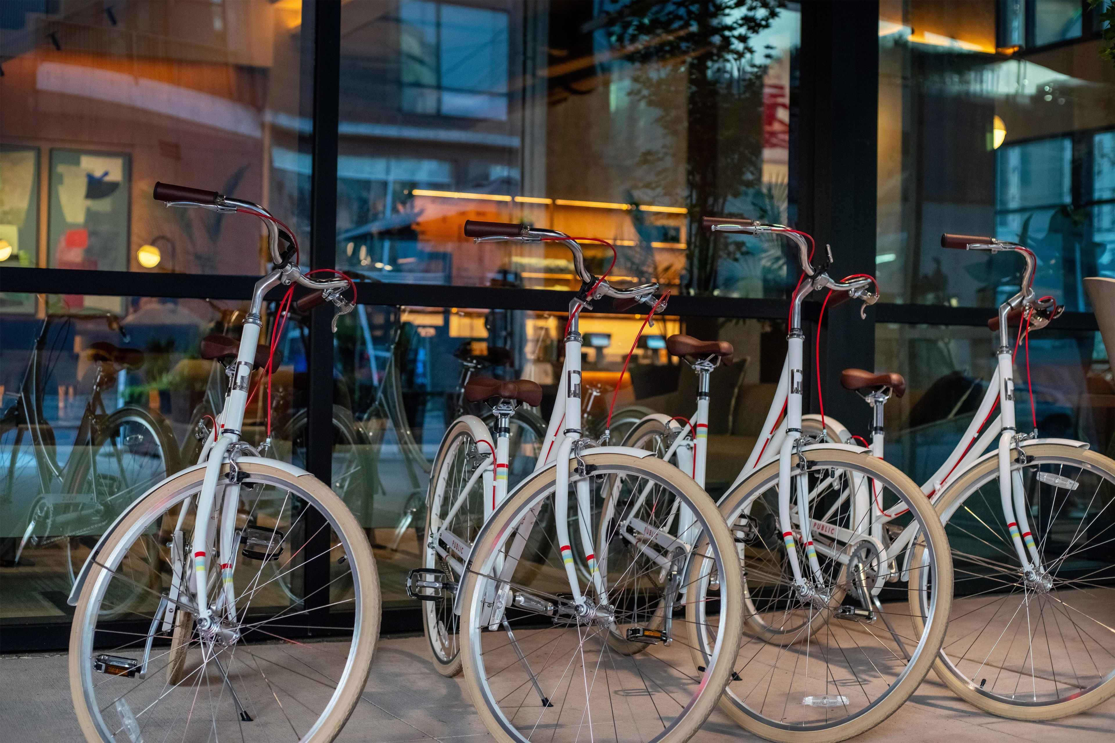 Bicicletas estacionadas frente a un edificio con ventanas amplias.