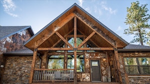 A rustic lodge with a stone facade, wooden porch, and a prominent 'GRAND POINT' sign. - Expansive 7 bedroom, 3 car garage, 2 hot tubs, paved roads, wifi & pool access (Lead)