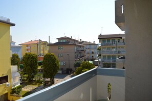 A residential area with multi-story buildings, balconies, and trees. - Comfortable Flat Close to the Beach (Caorle)