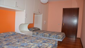 A bedroom with two beds, a wardrobe, and a door. - Bright House Near the Beach in Caorle (Caorle)