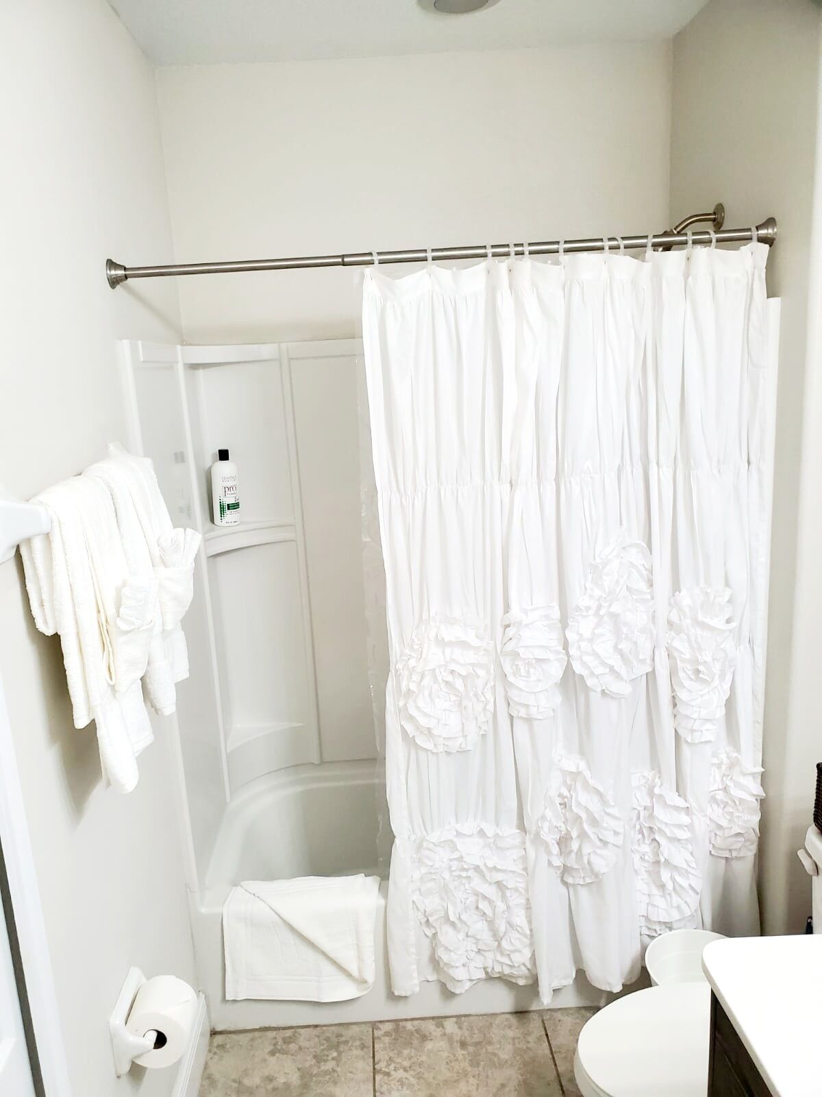 Une salle de bain équipée d’une douche, de toilettes et d’un porte-serviettes avec des serviettes.