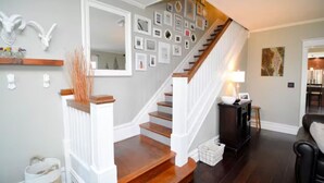 A staircase with a wooden finish, white railings, and a mirror above it. - The Big Belle of Bethlehem (Bethlehem)