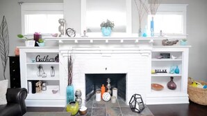 A living room with a white fireplace, shelves with decorative items, and a window with natural light. - The Big Belle of Bethlehem (Bethlehem)