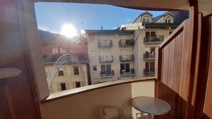 A balcony with a table and two chairs, overlooking a building with balconies. - 200m from ski lifts, 2nd floor, balcony, tv, 26m², Brides Les Bains (Brides-les-Bains)