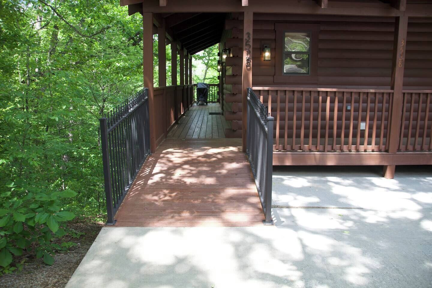 A wooden cabin with a covered porch and a concrete pathway leading to the entrance.