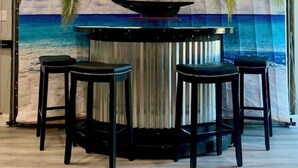 A bar area with a sailboat mural, two stools, and a counter. - Private Guest Suite with Shared Pool Access - just 9 miles from Boca Grande (Port Charlotte)