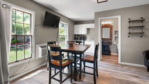 A modern kitchen with white cabinets, a built-in microwave, and a coffee maker.