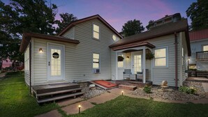A two-story house with a front porch, a small front yard, and a driveway. - In the center of all Historic Main Street has to offer (Grafton)