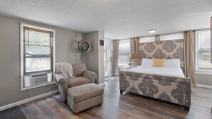A bedroom with a bed, a chair, and a small table. - In the center of all Historic Main Street has to offer (Grafton)