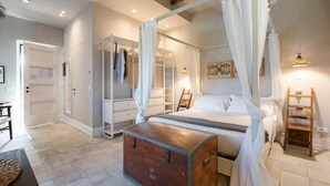 Une chambre à coucher avec un lit à baldaquin, une malle en bois, une armoire et une échelle.