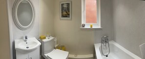A bathroom with a sink, toilet, and bathtub.