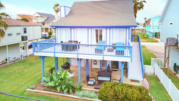A two-story house with a covered patio, a small garden, and a garage.