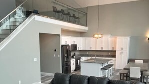 A modern living room with a sectional sofa, a marble coffee table, and a staircase leading to an upper level. - Amenity loaded golf course retreat! (Marion)