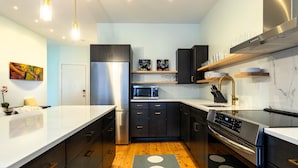 A modern kitchen with a central island, stainless steel appliances, and wooden flooring. - 50 Exchange Street Portland- 3B 
 (Portland)