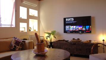 Appartement Confort | Coin séjour | Télévision à écran plat de 60 pouces avec chaînes par satellite, Netflix