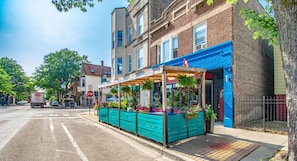 A street view with a row of buildings, a stop sign, and a parked truck. - Cozy Train Vibes + Rare Parking x3 (Chicago)
