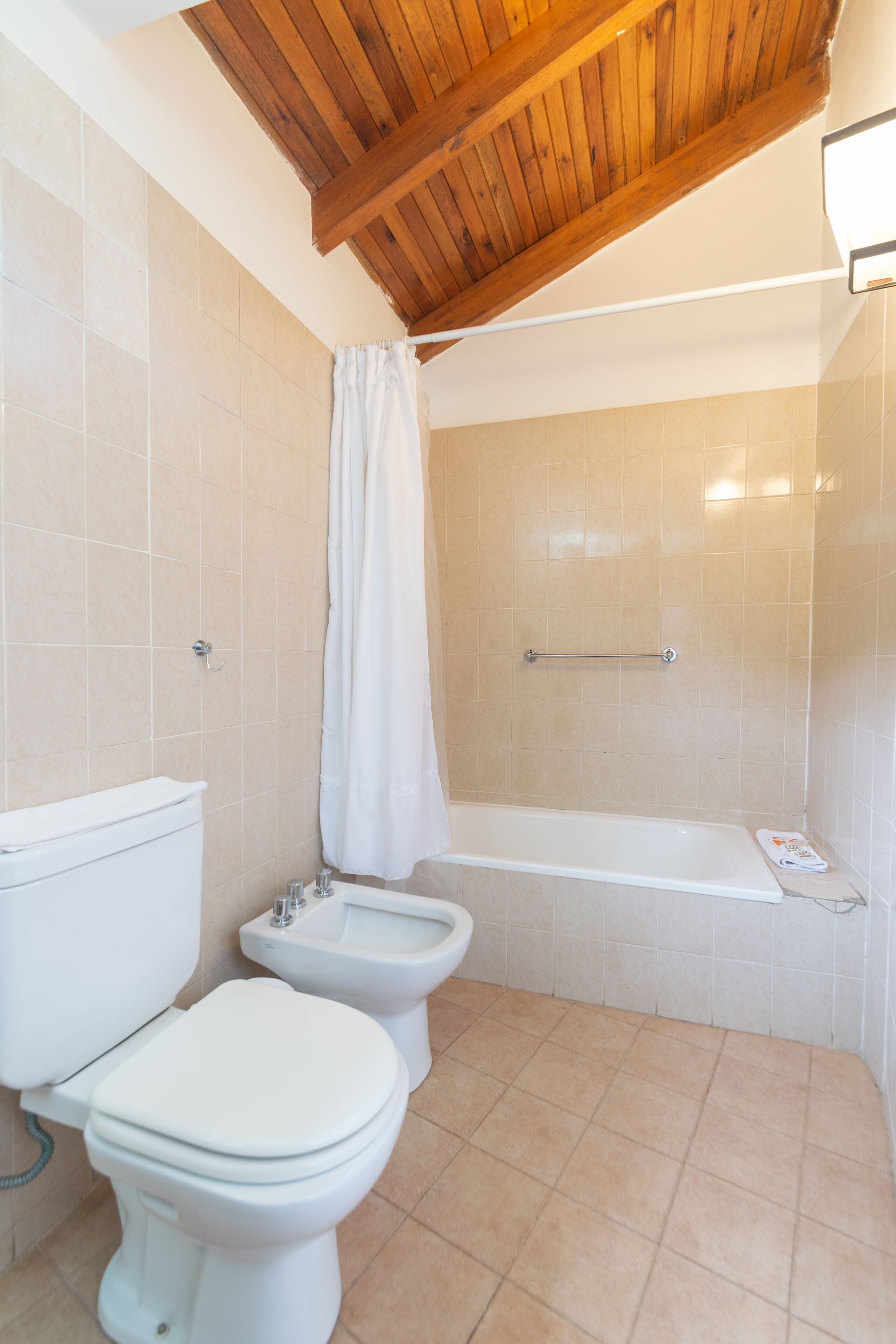 Un baño con inodoro, bidé y bañera.