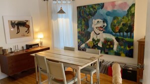 A dining area with a wooden table, chairs, a painting, and a dog. - Clean house in great neighbourhood! (Toronto)
