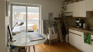A kitchen with white cabinets, a coffee machine, and a dining area with a table and chairs. - Clean house in great neighbourhood! (Toronto)
