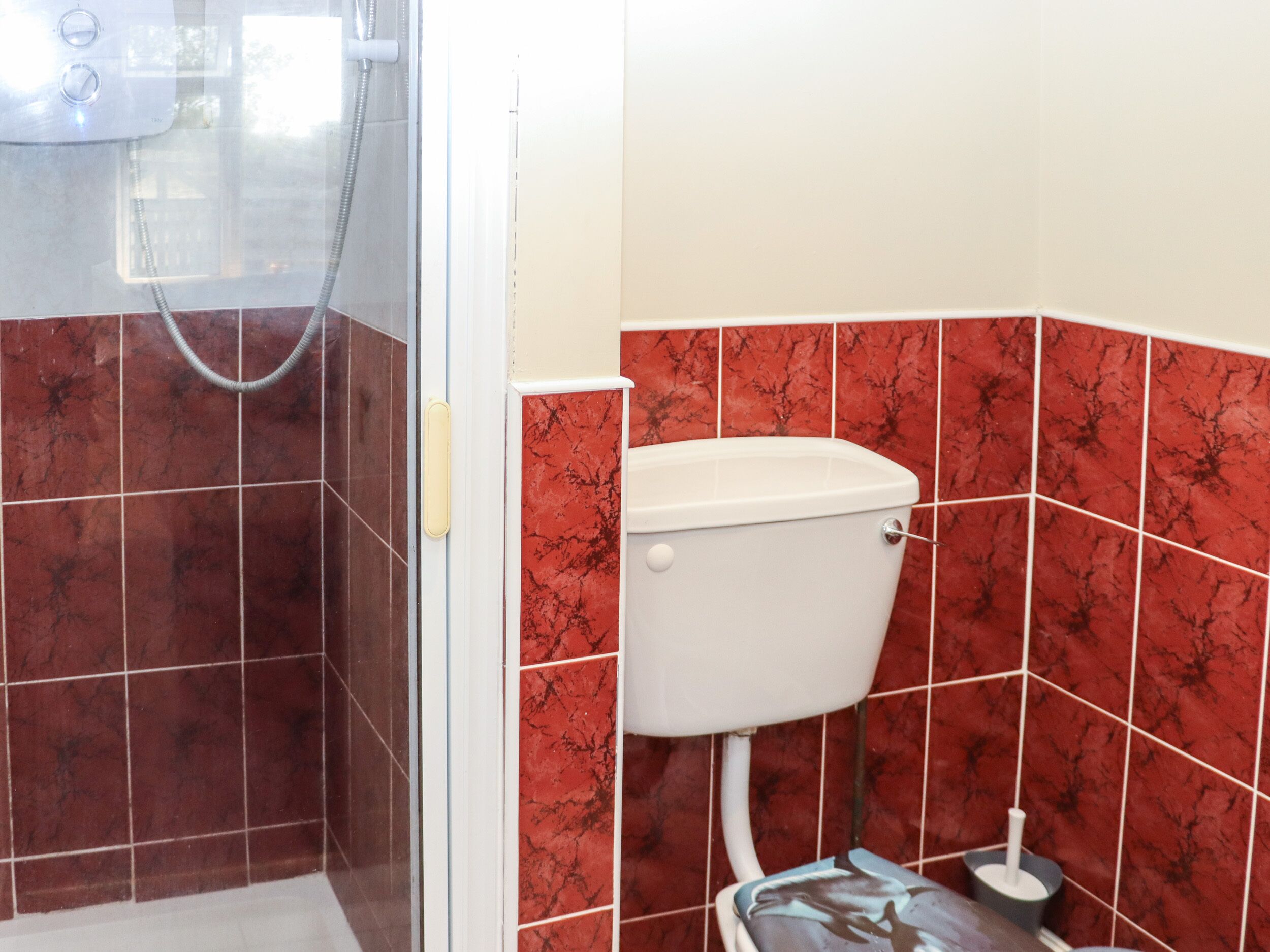 A bathroom with a shower, toilet, and bidet.