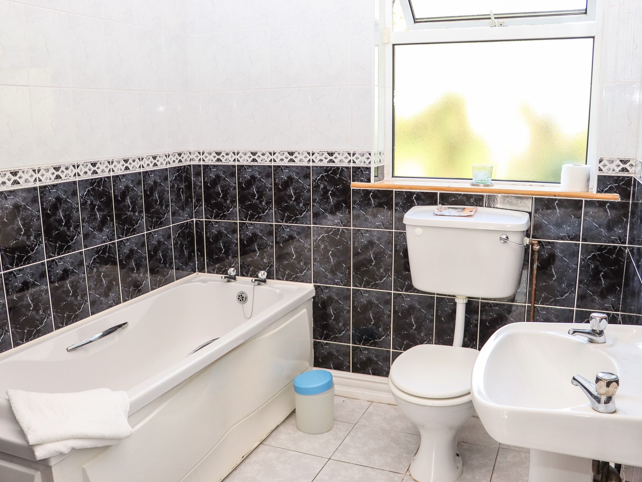 A bathroom with a bathtub, toilet, and sink.