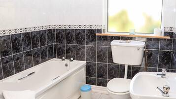 A bathroom with a bathtub, toilet, and sink.