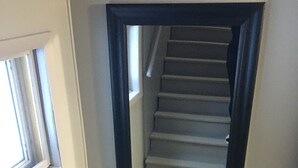 A narrow staircase with a dark frame, leading to a landing with a window. - The Superior Lodge - Located On Trail - Pictured Rocks Lakeshore, Munising MI (Munising)