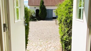 A stone pathway leading to a building with a metal roof.